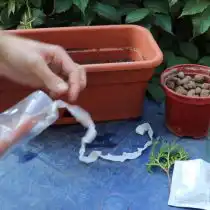 На дне стаканчиков пробить 2 отверстия. Протянуть через них шнур