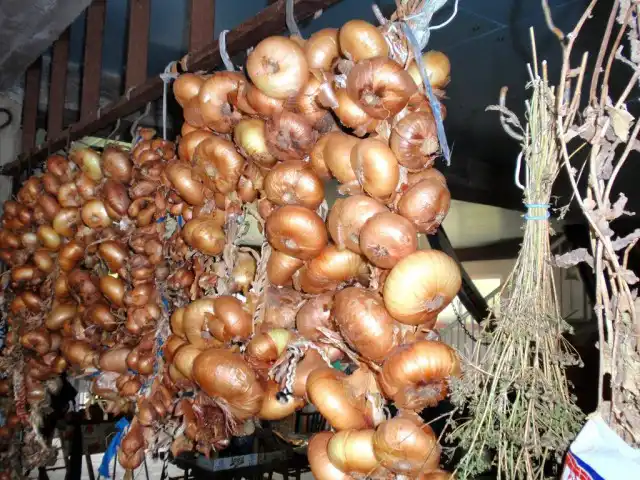 Сушить лук нужно с перьями, можно заплести их в косу